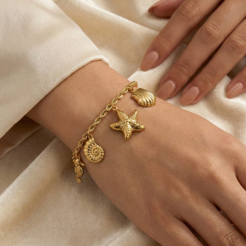 انسيال ذهبي أنيق مصنوع من الستانلس ستيل المقاوم للصدأ، بسلسلة مجدولة راقية تزينها دلايات أصداف ونجوم بحر بتفاصيل بارزة، مع قفل قابل للتعديل ليناسبكِ. - Image 4